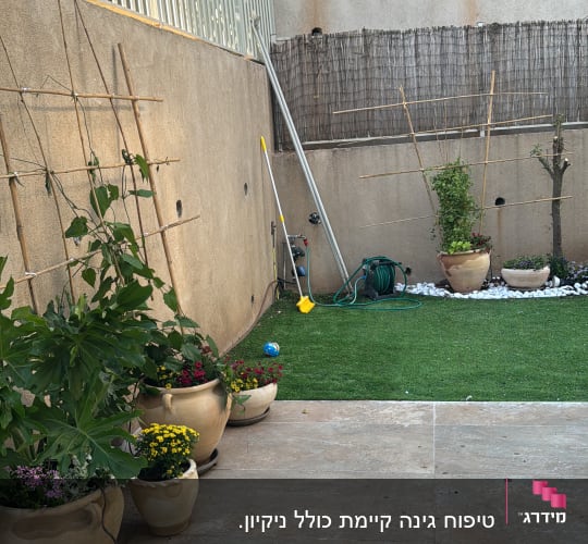עציצים עם פרחים, צינור השקיה, כלי גינון